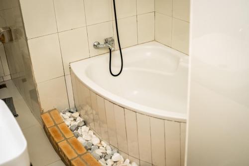 a bathroom with a bath tub with rocks around it at RJV Apartments, Meanwood Ibex Hill, Lusaka in Lusaka