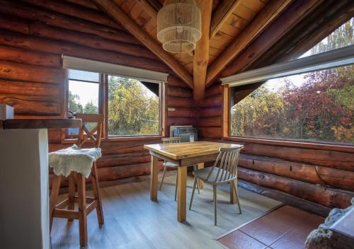 a dining room with a table and chairs in a log cabin at Ruma Andina by DOT Cabana in Villa La Angostura