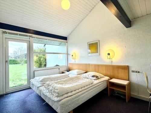 a bedroom with a large bed and a large window at M358-Vaeggerlose-Norrevang-38 in Bøtø By
