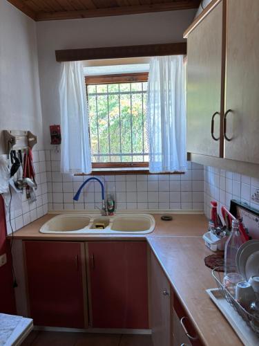 a kitchen with two sinks and a window at Το πετρόσπιτο in Doliana