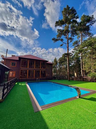a house with a swimming pool in the yard at ProLes Burabay Eco Hotel in Borovoye