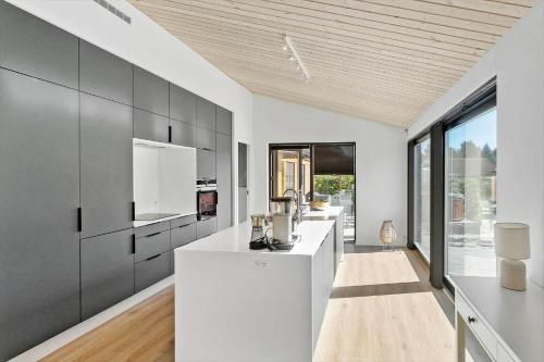 a kitchen with white counters and black cabinets at M350-Vaeggerlose-Grapilevej-2-A in Marielyst