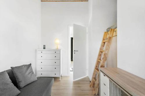 a living room with a couch and a dresser and a ladder at M350-Vaeggerlose-Grapilevej-2-A in Marielyst