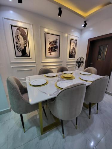 a dining room with a white table and chairs at Super Luxury 3bedroom Apartment in Gbagada in Lagos