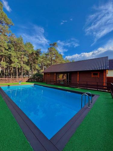 a large swimming pool in front of a house at ProLes Burabay Eco Hotel in Borovoye