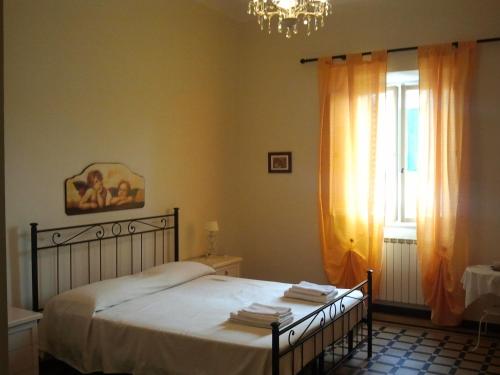 a bedroom with a bed with a chandelier and a window at B&B IL TABERNACOLO in Florence