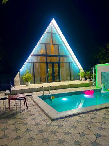 VǝndamにあるA-frame Houseの夜の建物の前のプール