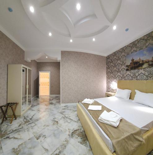 a bedroom with a large bed and a marble floor at Kolizey Hotel Spa Ganja in Ganja