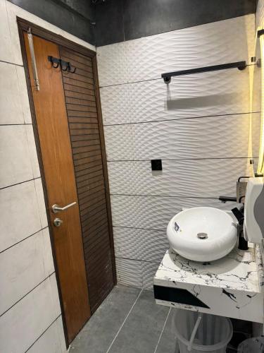 a bathroom with a toilet and a wooden door at Double Delight-Two Single Beds, Private Entrance Available On Sharing Also in Karachi