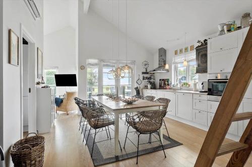 a white kitchen with a table and chairs at L28-Nysted-Marsvinvej-3 in Nysted