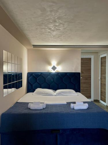 a bedroom with a blue bed with two towels on it at Jacuzzi Apartman PK Pančevo in Pančevo