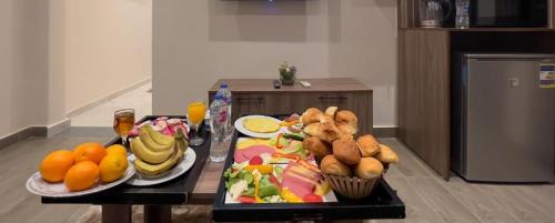 a table with plates of food and fruit on it at Alaska Pyramids Hotel in Cairo
