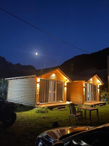 a house with a table in front of it at night at Thethi Mountain Villas in Theth