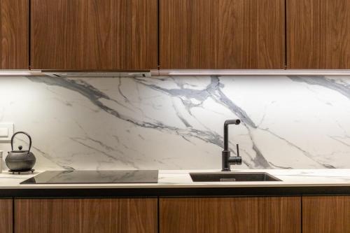 a kitchen with a sink and a marble counter top at Golden Dunes & SPA in Nida