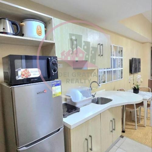 a kitchen with a stainless steel refrigerator and a sink at Cedar Peak Baguio Condo Transient by Dei Gratia in Baguio