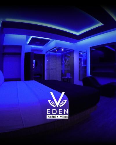 a bedroom with a bed with a blue lighting at Hotel y Villas V Edén Atlacomulco 