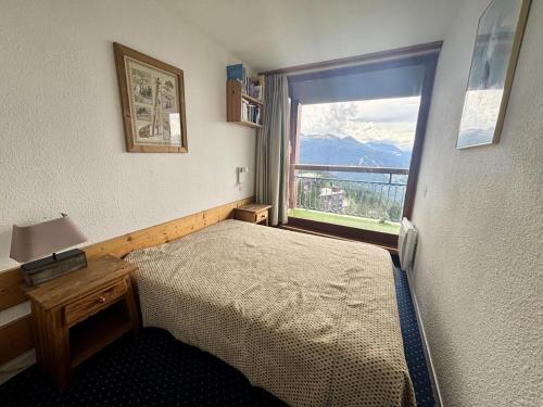 a bedroom with a bed and a window with a view at Résidence Nova 3 - Appartement 2 pièces 6 personnes proche des pistes MAE-2143 in Arc 1800