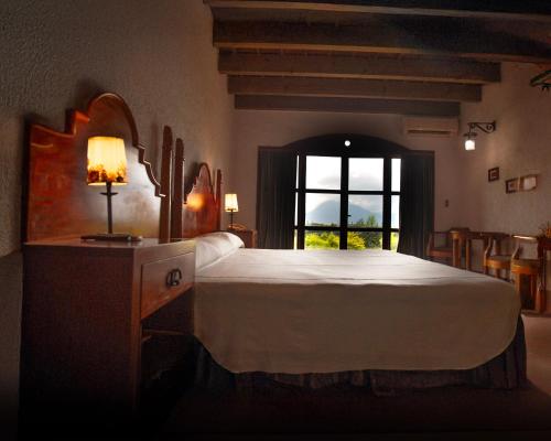 a bedroom with a large bed and a window at Hotel Posada de Don Rodrigo Panajachel in Panajachel
