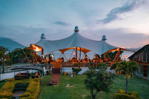 a large tent with tables and chairs under it at Hotel Posada de Don Rodrigo Panajachel in Panajachel