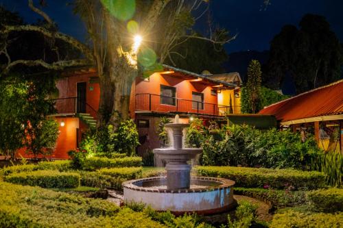 a fountain in front of a house at night at Hotel Posada de Don Rodrigo Panajachel in Panajachel