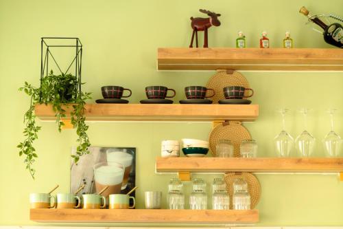 a shelf filled with glasses and bottles on a wall at Olive Stays Apartment - 1 in Pristina