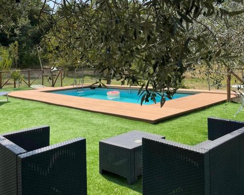 a swimming pool in a yard with two chairs at La Casa di Farfa - Lovely Home in Sabina in Bocchignano