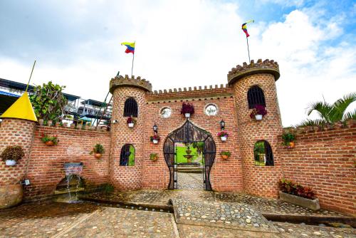 a brick building with two flags on top of it at hotel y restaurante siga la vaca pavas la cumbre in La Cumbre