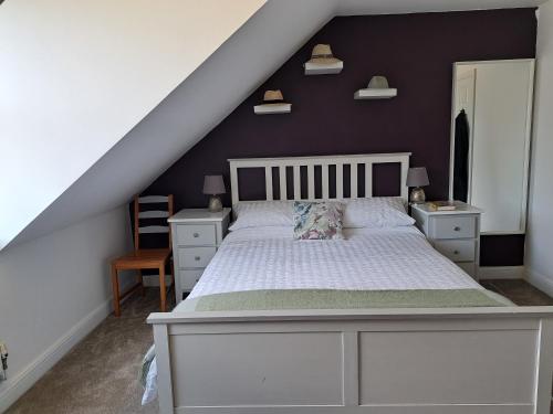 a bedroom with a white bed and a black wall at All Saints Crescent in Westbury