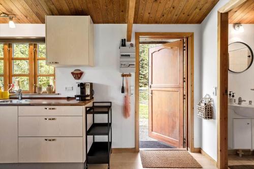 a kitchen with white cabinets and a wooden door at M370-Vaeggerlose-Boto-Ringvej-22 in Bøtø By