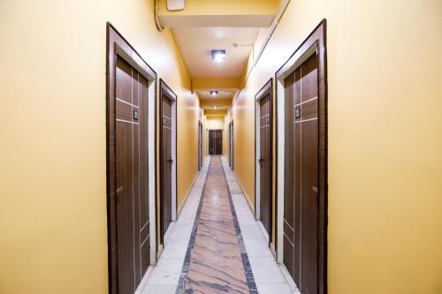 an empty corridor of a hallway with brown doors at Super Collection O Nimisha Jail Rd in Sītāpur