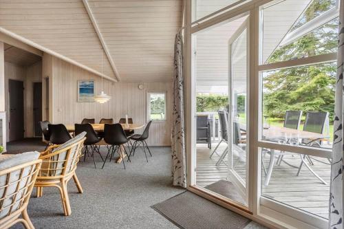a dining room with a table and chairs and a glass door at M369-Vaeggerlose-Mimosevej-19 in Marielyst