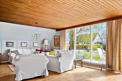 ein Wohnzimmer mit weißen Möbeln und einem großen Fenster in der Unterkunft M374 Gedser - Birkevej 3 in Gedser
