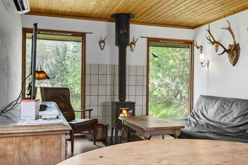 ein Wohnzimmer mit einem Holzofen und einem Tisch in der Unterkunft L38 Rødby - Lærkevænget 10 in Rødby