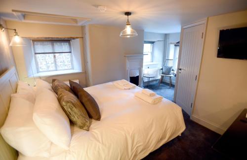 a bedroom with a large white bed with pillows at The Chequers Inn, Thornham in Thornham