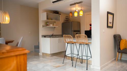 a kitchen with a counter and stools in a room at Ka' Romana Residences in El Soco