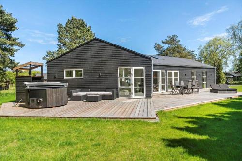 a black house with a deck with a grill at M379-Vaeggerlose-Baeverstien-43 in Marielyst