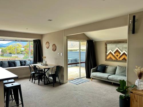 a living room with a table and a couch and a dining room at Spacious Family Home in Te Anau in Te Anau
