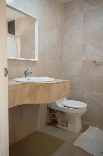 a bathroom with a sink and a toilet at Ka' Romana Residences in El Soco