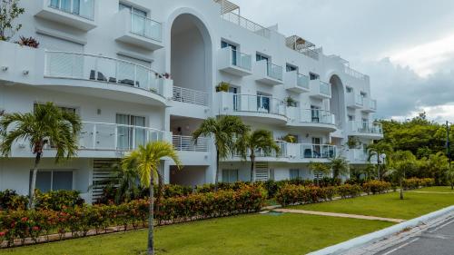 a large white building with palm trees in front of it at Ka' Romana Residences in El Soco