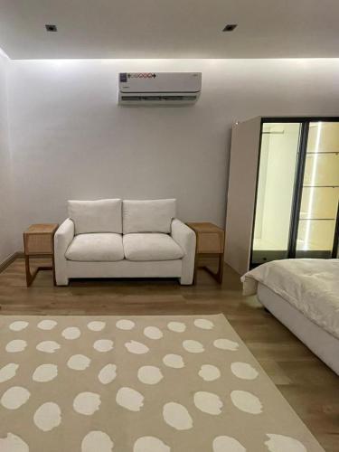 a living room with a white couch and a bed at DownTown Suites OrbitNet RUH 4 in Riyadh