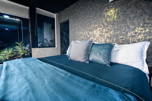 a bedroom with a large bed with blue sheets and pillows at hotel y restaurante siga la vaca pavas la cumbre in La Cumbre