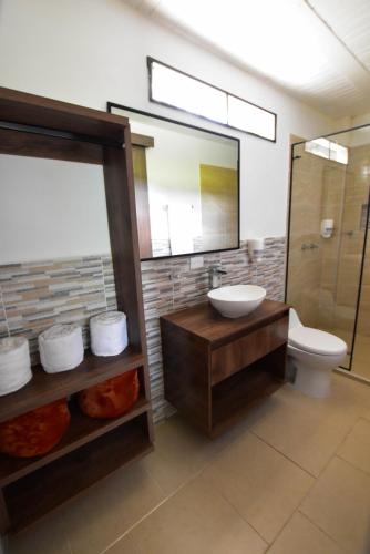 a bathroom with a sink and a toilet and a mirror at hotel y restaurante siga la vaca pavas la cumbre in La Cumbre