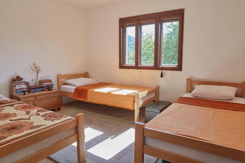 a room with three beds and a window at Foreside Escape Montenegro in Žabljak