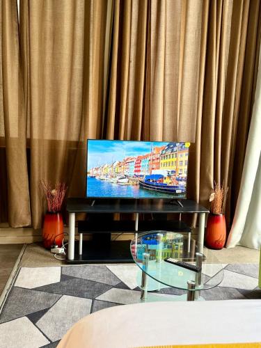 a tv sitting on a table in front of a curtain at Isibaya House in Johannesburg