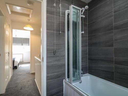 un baño con bañera y ducha de cristal en 32 Moorland House, en Leicester