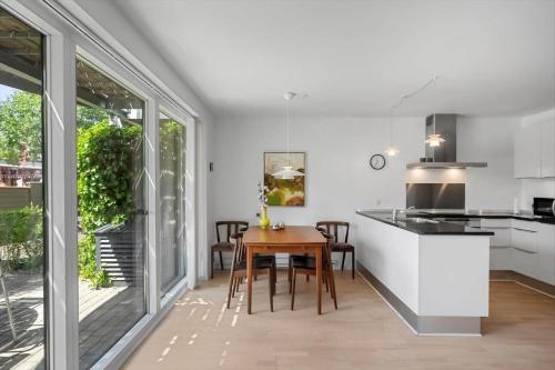 a kitchen and dining room with white cabinets and a table at M384-Vaeggerlose-Marielyst-Strandvej-63-B in Marielyst