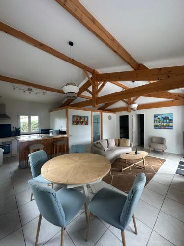 Una sala de estar con una mesa y sillas de madera. en Villa Gainsbourg, en Andernos-les-Bains