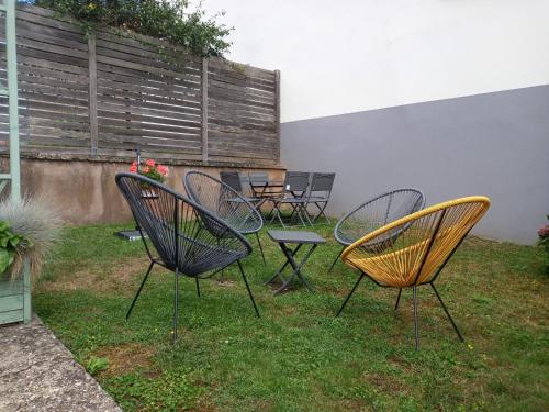 a group of chairs and tables in a yard at Chez Jeanne, charmante maison in Dossenheim-sur-Zinsel