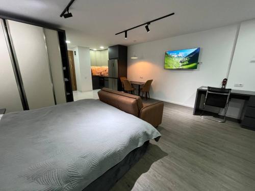 a bedroom with a bed and a desk and a kitchen at BatumiView in Batumi