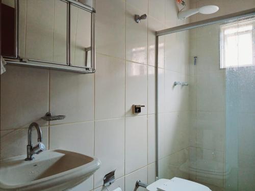 a bathroom with a sink and a glass shower at Casa Águas de Lindóia x Monte Sião Perto Brasílis CT in Águas de Lindóia